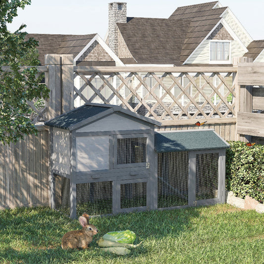 Wooden rabbit hutch with a rabbit in front, set against a house and garden backdrop.